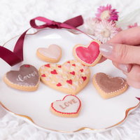 ピンクとブラウンのハート型クッキーを手に取った瞬間の写真