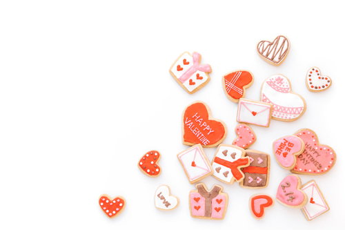 ピンク・赤・白のアイシングで装飾された散らばったハート型のクッキー