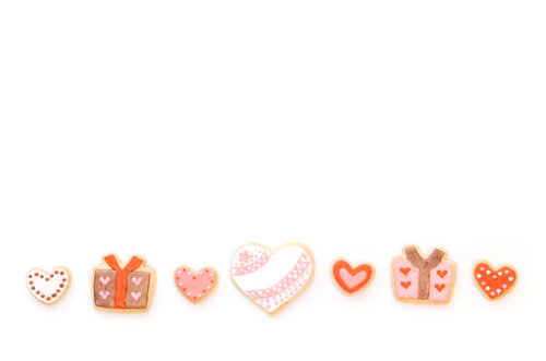 横一列に並んだピンク色のハート型クッキーとギフトボックス