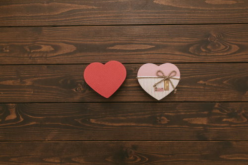 木製テーブルに置かれたハート型の箱とリボン