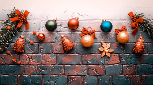 レンガ壁に並ぶクリスマスオーナメントと松の枝飾り