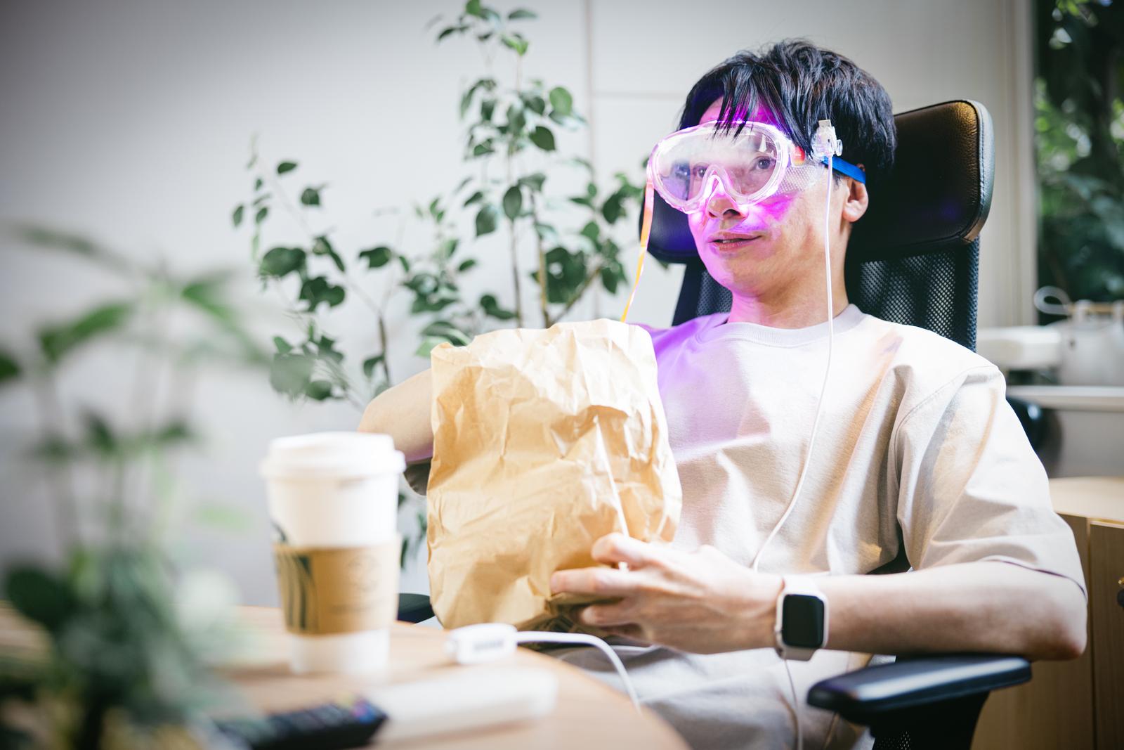 ARゴーグルを装着してデスクに座る男性が映画を鑑賞している［モデル：金子周平］