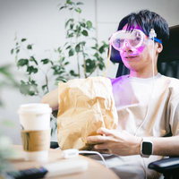 ARゴーグルを装着して仮想空間で映画鑑賞する男性の写真