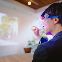 ARゴーグルで仮想モニターを操作する男性の写真