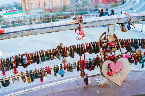 手すりに括り付けられたカラフルなハート型の南京錠の数々