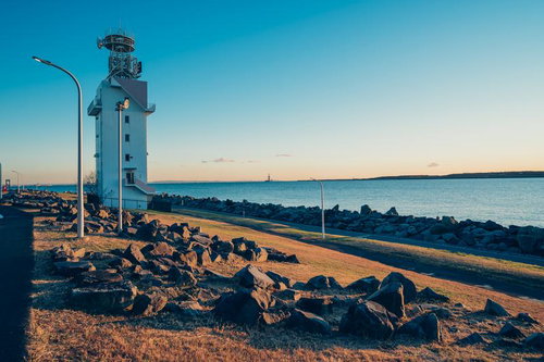 夕焼けに染まる若洲海浜公園の海岸と灯台