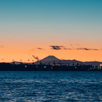 若洲海浜公園から東京湾越しに望む夕焼け空と富士山のシルエットの写真
