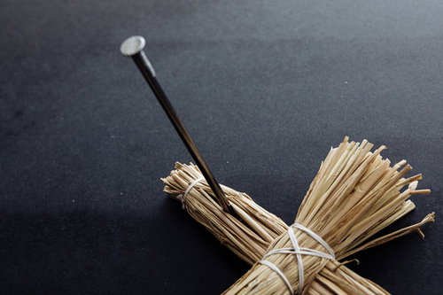 右腕に五寸釘を打たれた藁人形：呪いと怨念の象徴