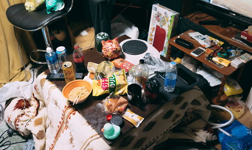 食べ残しやゴミが散乱した汚部屋のこたつ