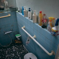 浴室の棚に並ぶシャンプーとバスケア用品の収納の写真