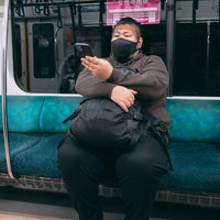 電車でスマホを操作するデブの写真