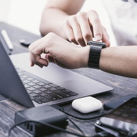AppleWatch の通知を確認するエンジニアのデスクワークの写真