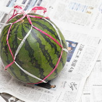 新聞紙に包まれたスイカを買ってきました。夏の食材の写真