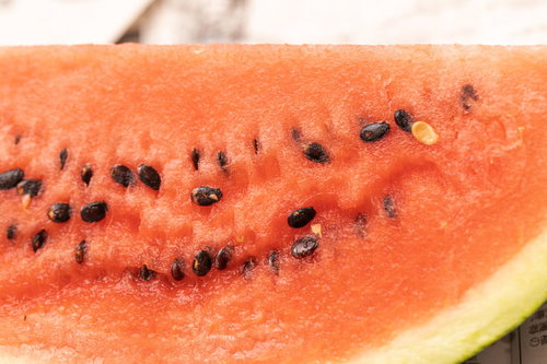 赤い果肉に黒い種が並ぶすいかの断面図