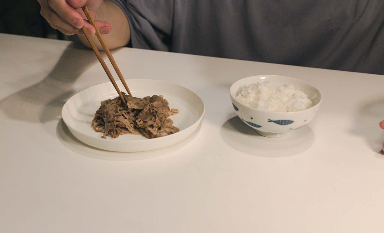 白い皿に盛られた牛皿と茶碗に入った白米、箸が置かれた食事セット