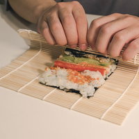 海苔の上に具材をのせて巻く、手巻き寿司を巻いてるとこの写真