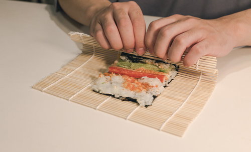 海苔の上に具材をのせて巻く、手巻き寿司を巻いてるとこ