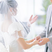 神父に祝福される新郎新婦の写真