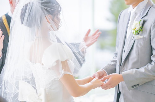 神父に祝福される新郎新婦