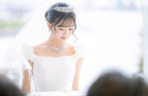ウエディングドレスの花嫁が結婚証明書にサインをする