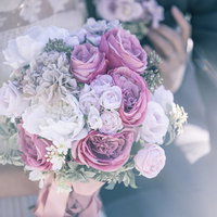 白とピンクのバラとトルコキキョウのブーケを抱く花嫁の写真