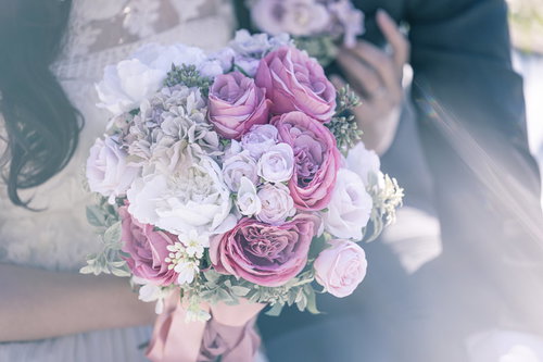白とピンクのバラとトルコキキョウのブーケを抱く花嫁