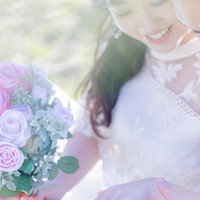 結婚指輪を確認しあう新郎新婦とピンク薔薇のブーケの写真