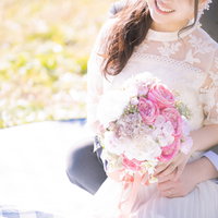 ブーケを持った新婦を後ろから抱きしめる新郎の写真