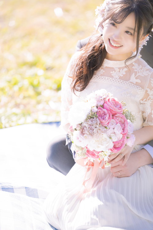 ブーケを持った新婦を後ろから抱きしめる新郎