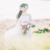 自己主張が激しい花嫁、ブーケを手に野原に立つの写真