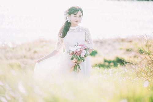 自己主張が激しい花嫁、ブーケを手に野原に立つ