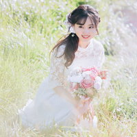 白いレースドレスのブーケを持って笑顔の花嫁の写真