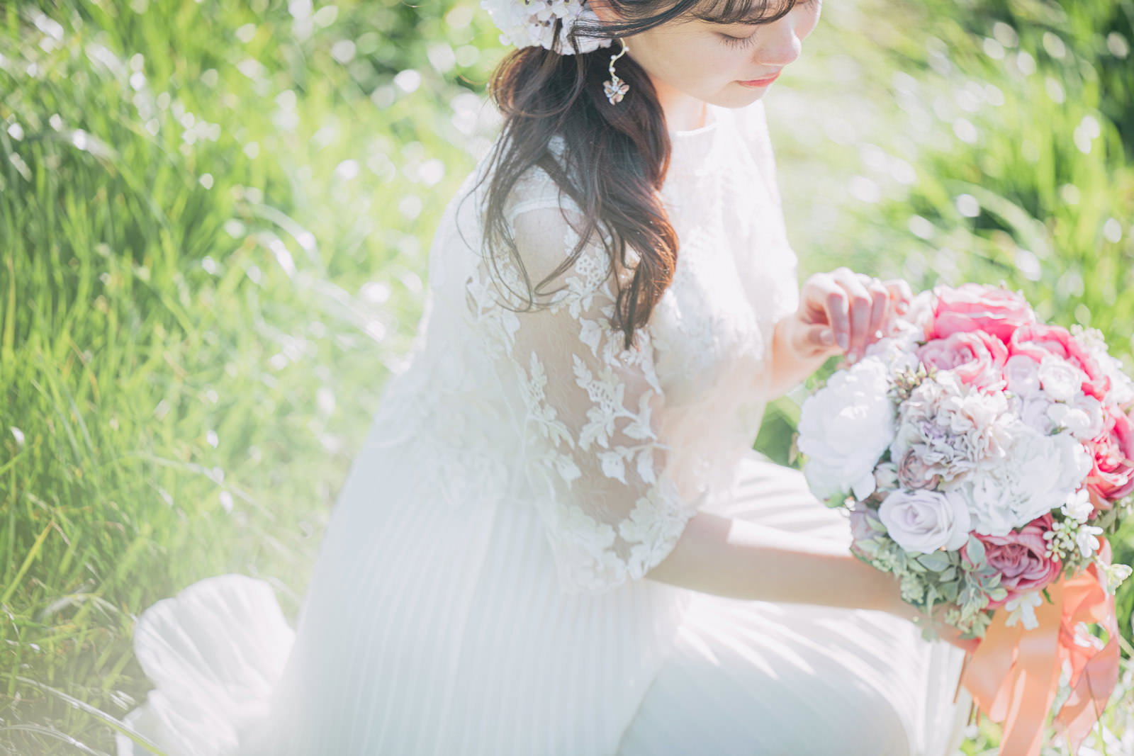 白いレースドレスを着た花嫁がピンクと白のバラのブーケを手に持つ［モデル：河村友歌］