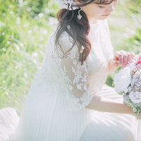 白いレースドレスを着た花嫁がブーケを触るの写真