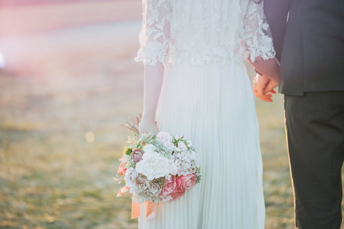 ずっと一緒だよ、新郎新婦が手を握るブーケ姿の結婚式