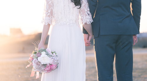 未来へ向かって手を握り歩き出す新婚夫婦のウェディング