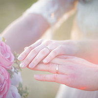 ブーケと結婚指輪をつけた二人の手の写真