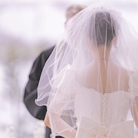 誓いの言葉を交わす花嫁の後ろ姿、白いベールとウエディングドレスの写真