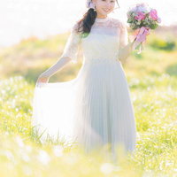 ブーケを持った花嫁の女性がウェディングドレスで笑顔で立つポートレートの写真