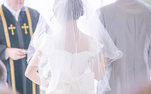 牧師の前で誓いの言葉を述べる花嫁、新郎と教会式の結婚式