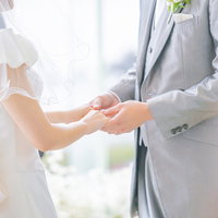 結婚式で指輪交換を終えて花嫁の手をそっと握る新郎の手元の写真