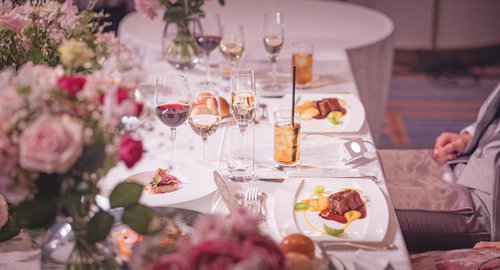 ピンクの花に彩られた披露宴の新郎新婦の席