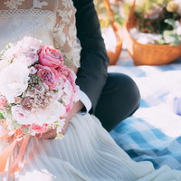 ウエディングドレスを着た花嫁がピンク色のブーケを持つおでかけウエディングの写真