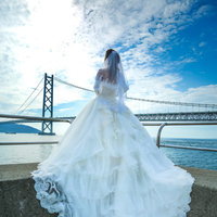 明石海峡大橋を背景にしたウェディングドレス姿の女性の写真