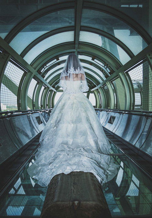 近未来的な通路を歩くウェディングドレス姿の女性