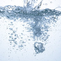 ミネラルウォーターが注がれる水の断面と気泡の写真