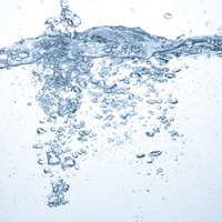 水槽に注がれる水の断面と気泡、ミネラルウォーターの透明感の写真
