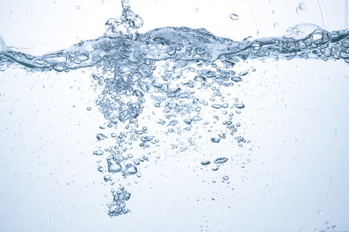 水槽に注がれる水の断面と気泡、ミネラルウォーターの透明感