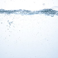 水槽のミネラルウォーターに浮かぶ気泡と水面の断面の写真