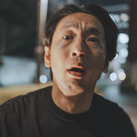 夜の繁華街で呆然とする男性の写真